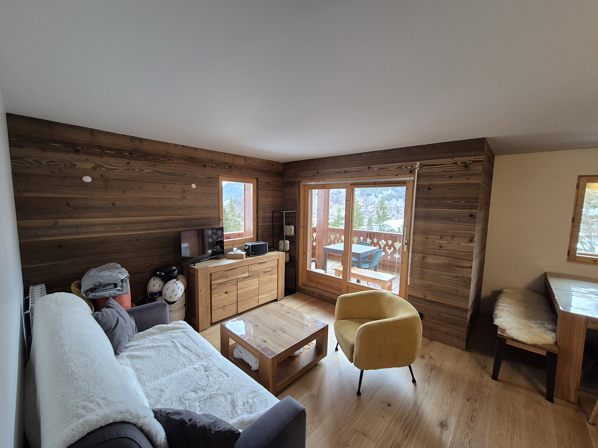 Salon rénové avec parquet et lambris bois dans un appartement de montagne en Haute-Savoie