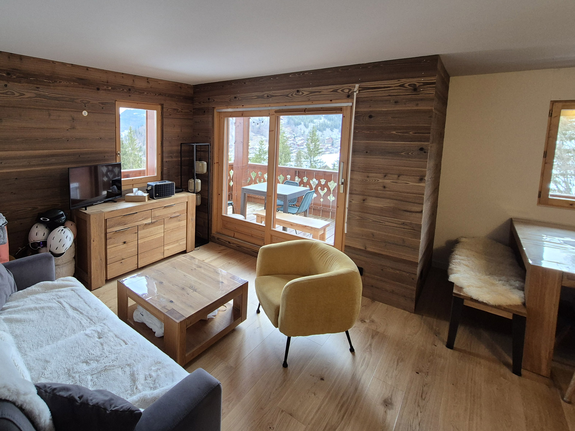 Salon rénové avec parquet et lambris bois dans un appartement de montagne en Haute-Savoie après travaux