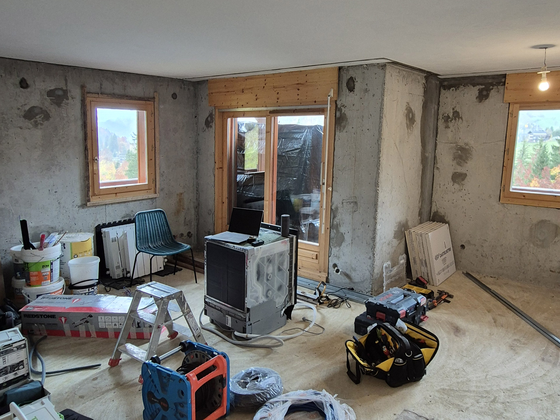 Salon en cours de rénovation avec murs bruts et chantier dans un appartement en Haute-Savoie